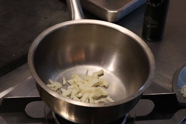 鍋に薄切りにんにくを入れる